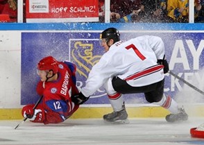 MALMO, SWEDEN - DECEMBER 28: Russia's Ivan Barbashev #12 gets tangled up with Switzerland's Benoit Jecker #7 and crashes into the board during preliminary round action at the 2014 IIHF World Junior Championship. (Photo by Andre Ringuette/HHOF-IIHF Images)